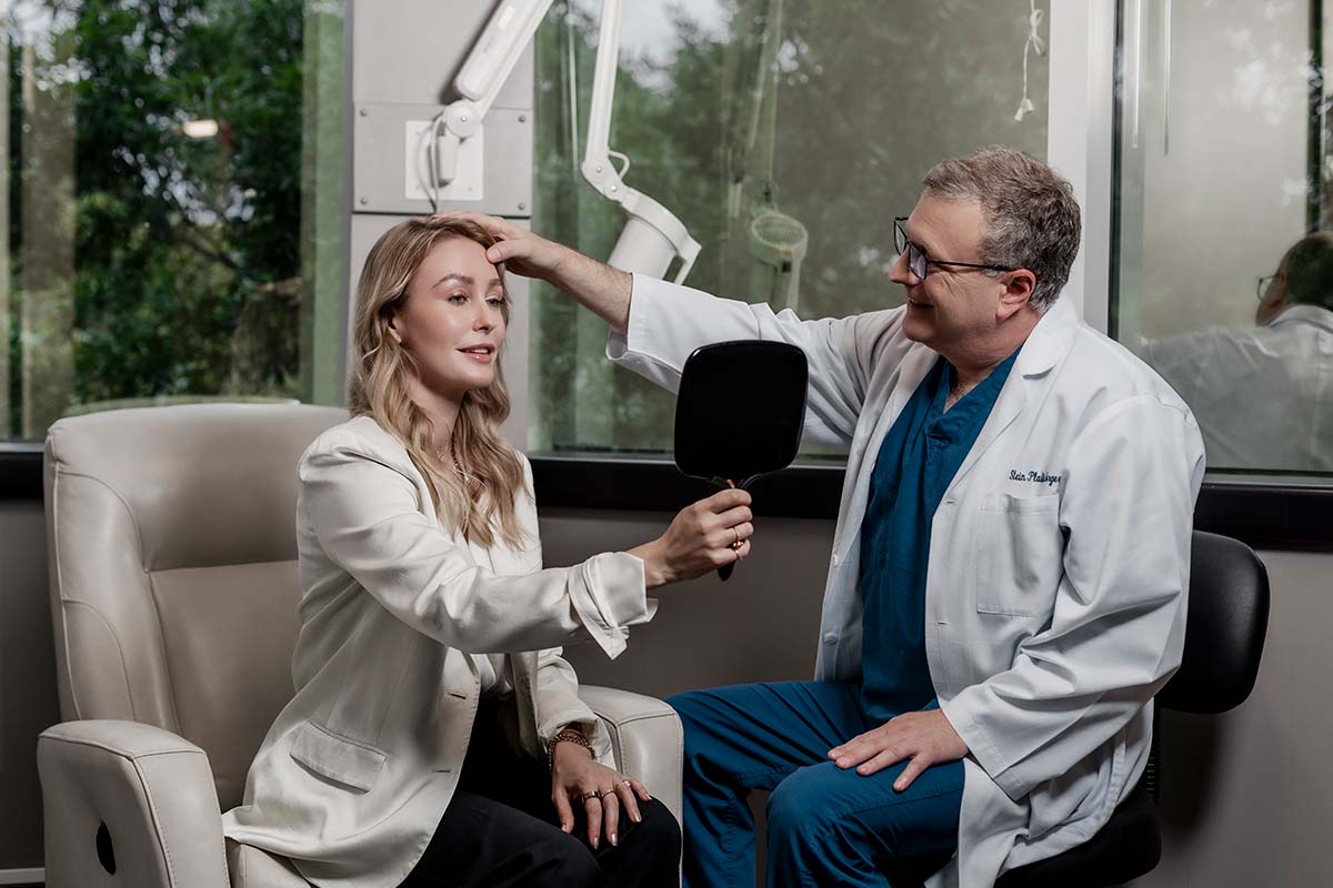 Dr. Stein looking at a patient's face before her blepharoplasty in Raleigh