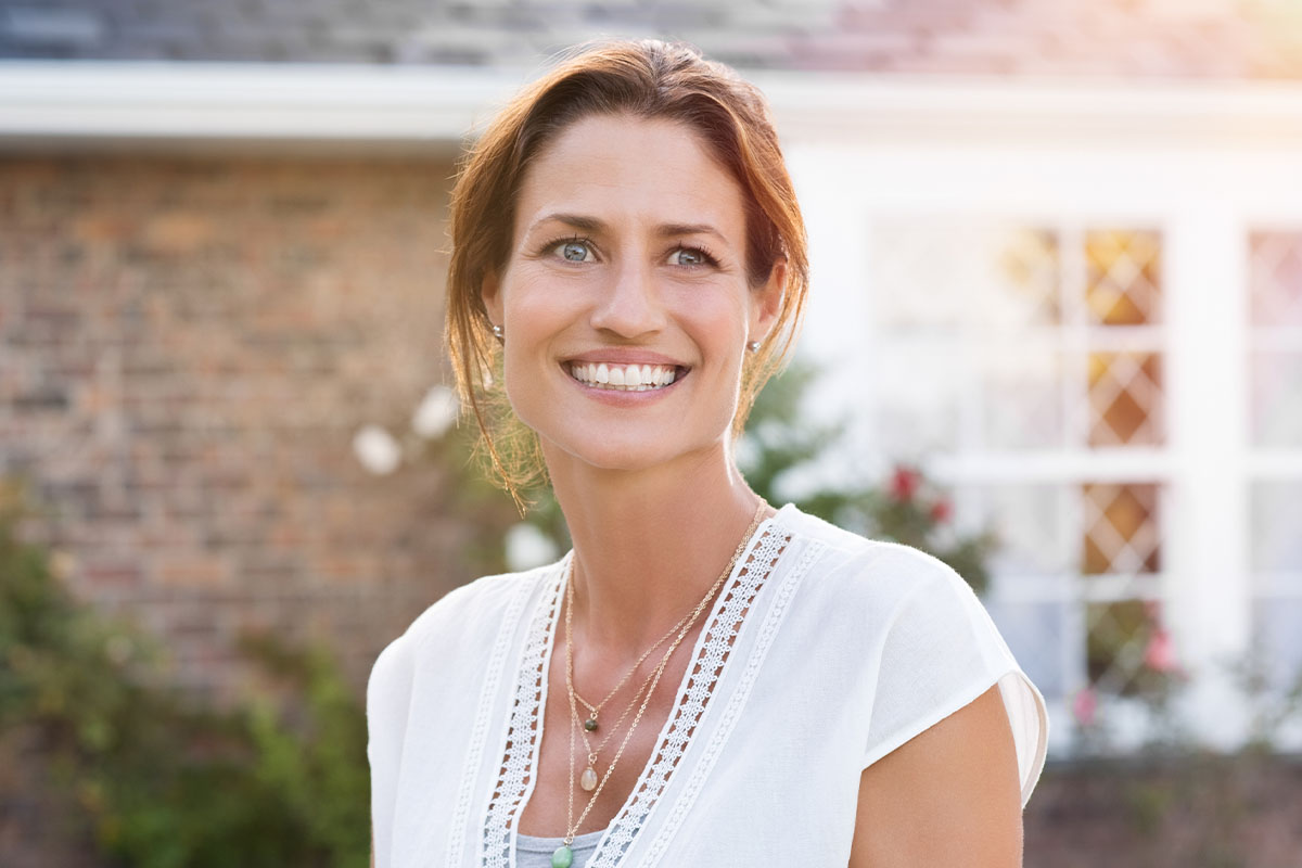a woman smiling after getting eyelid lift surgery in Raleigh