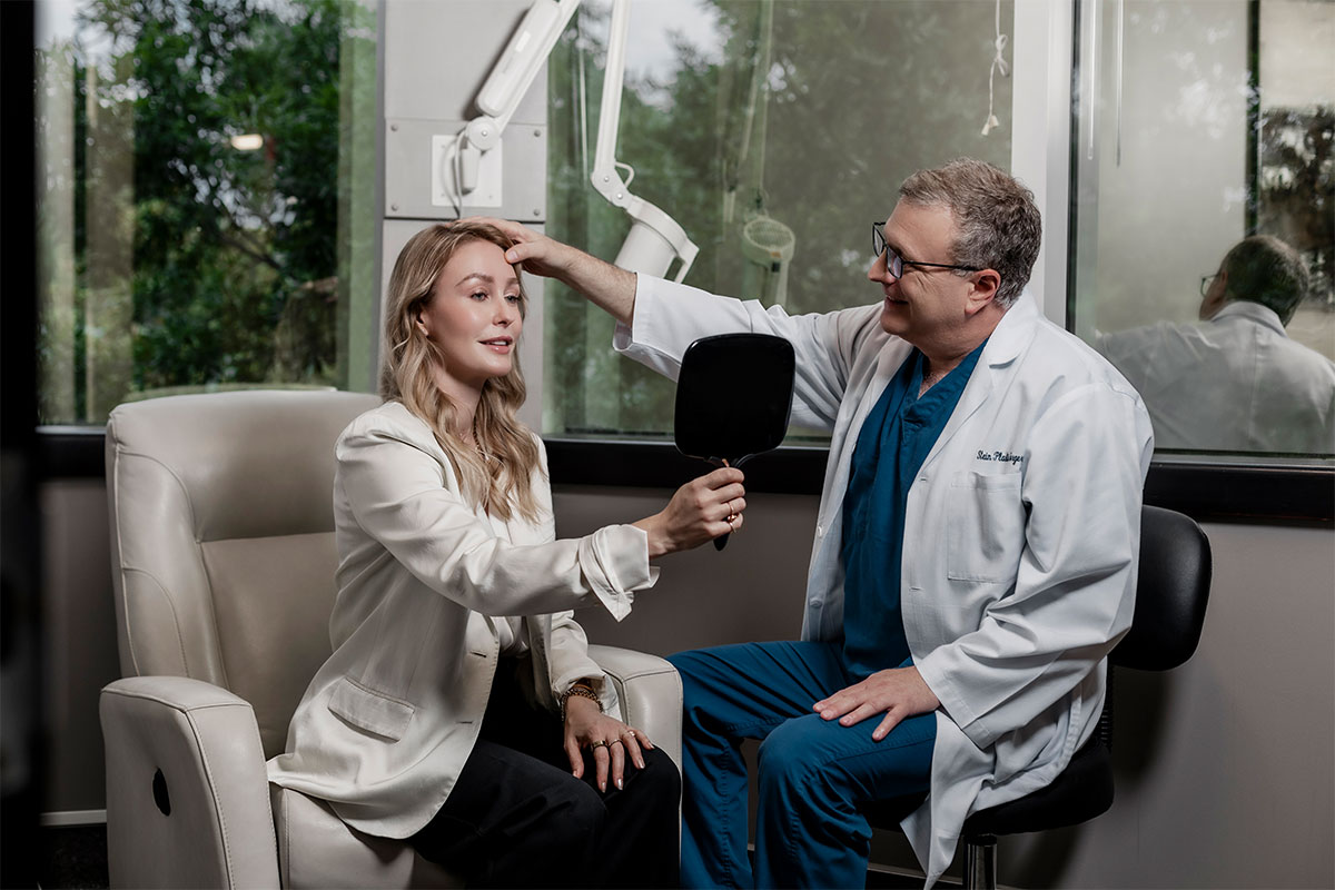 Dr. Stein looks at a patient's face after she gets an endoscopic forehead lift in Raleigh
