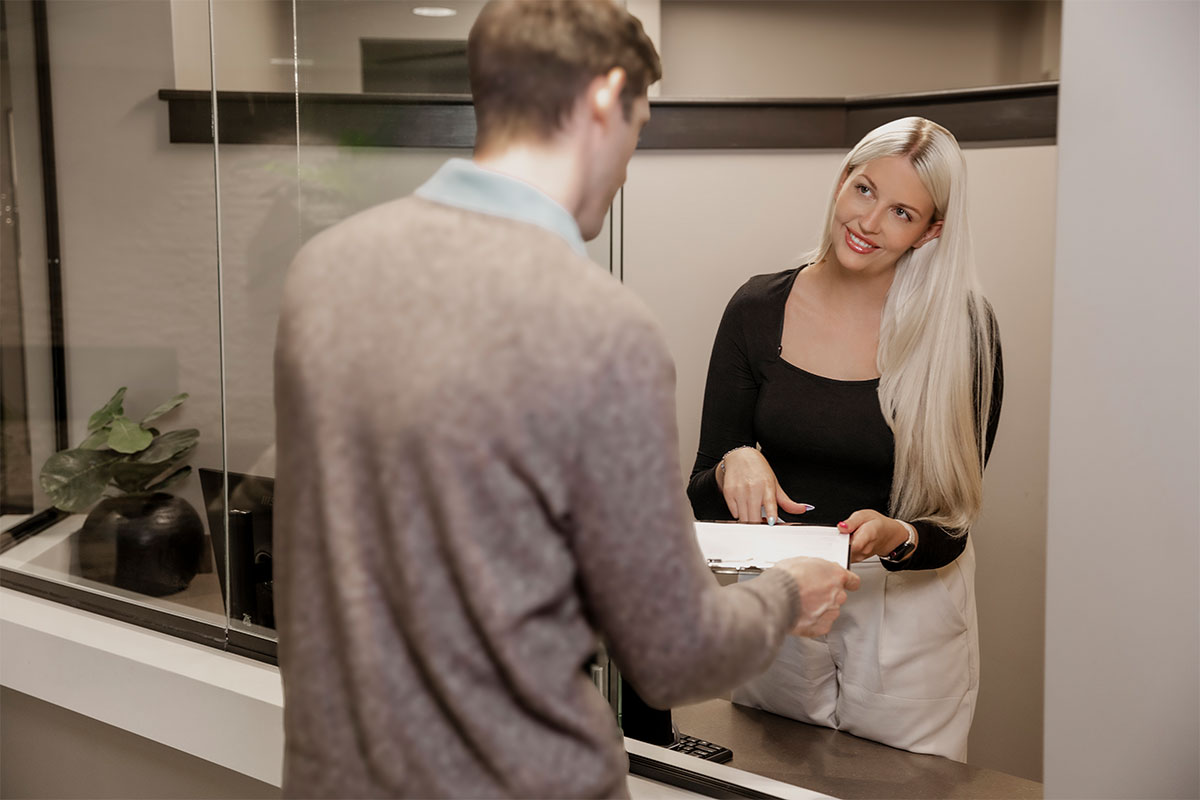 a receptionist showing a patient paperwork before getting neck lipo in Raleigh at Stein Plastic Surgery