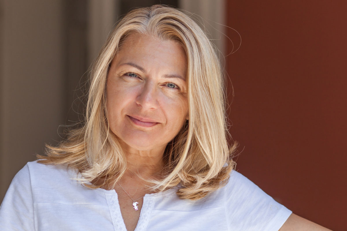 a woman looking at the camera with a slight smile on her face after getting a midface lift in Raleigh at Stein Plastic Surgery